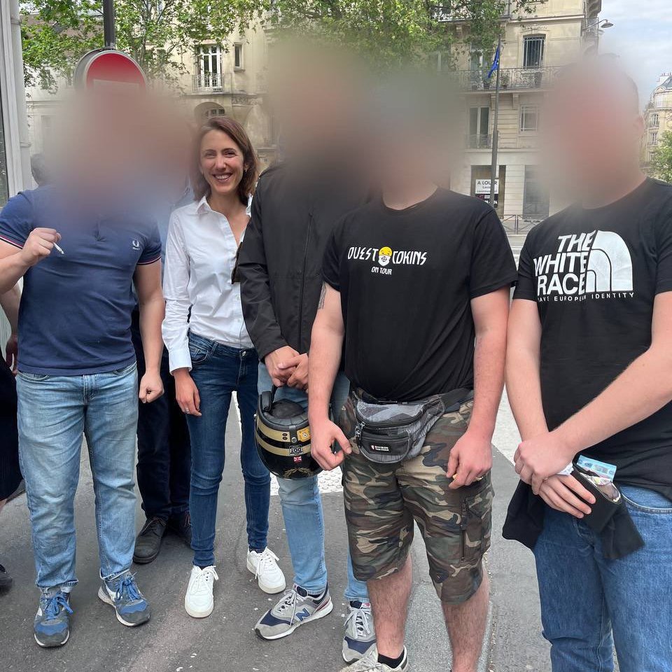 Valérie Hayer, tête de liste de @Renaissance le parti de Macron, se retrouve sur une photo avec des néo-nazis

Deux t-shirts : 
- L'un 'White Race' pas besoin d'explications ...
- L'autre 'Ouest Cokins' avec des S à a typo des SS, car c'est un groupe de 'Rock Aryen' néo-nazi