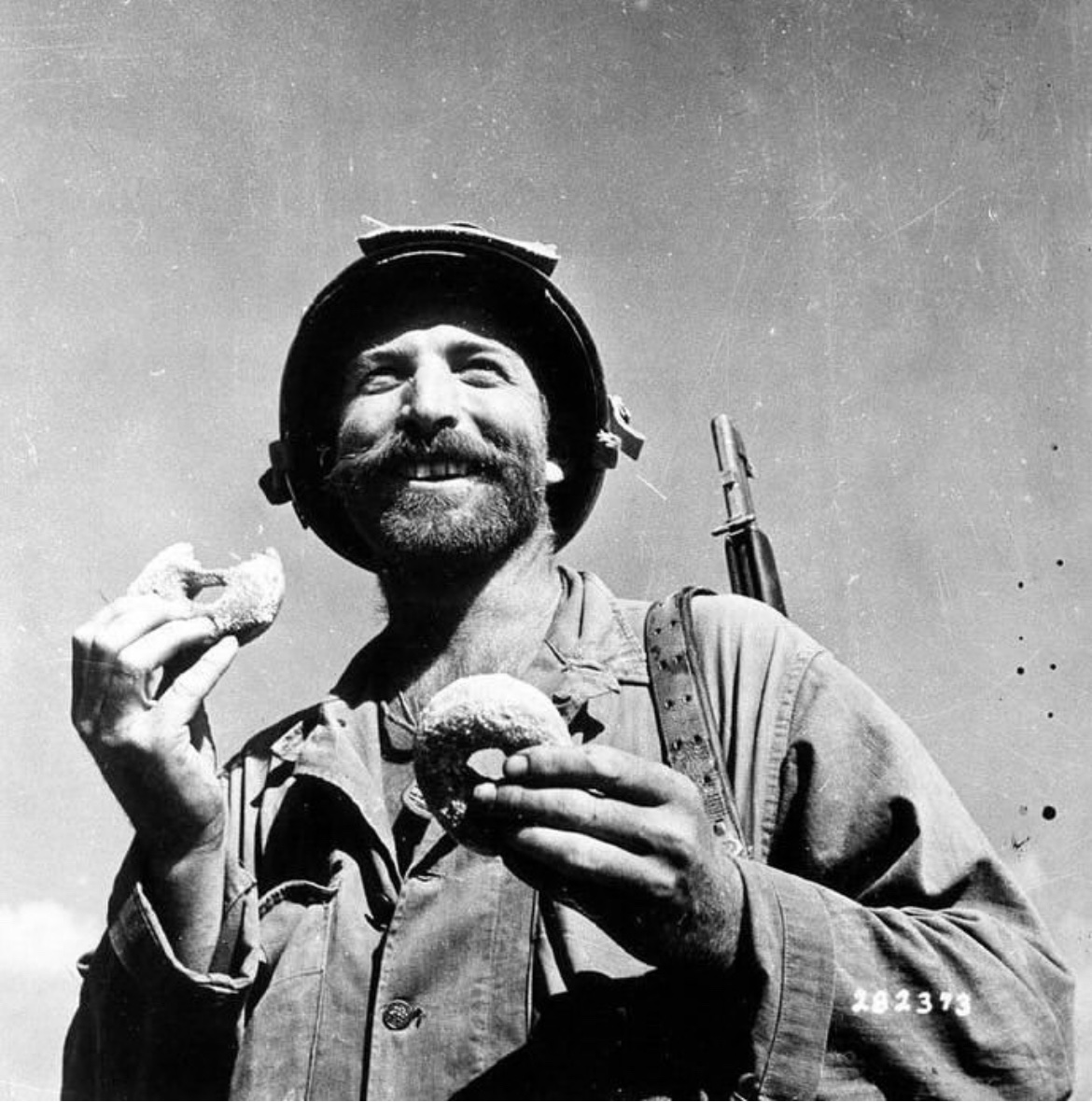 During the fighting on Okinawa, a bearded GI enjoys a doughnut in 1945. 🪖