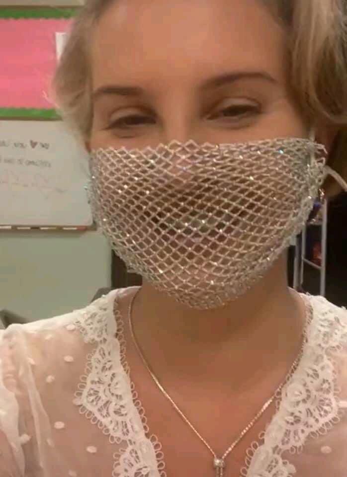 solelynostalgia's tweet photo. Lana Del Rey wearing a mesh mask during a book signing https://t.co/d8LU76LyU8