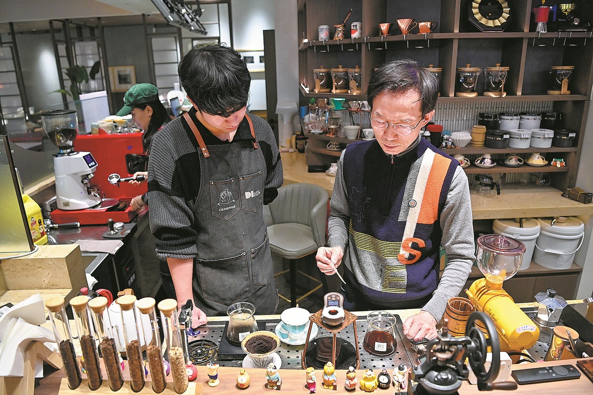 A South Korean barista demonstrates coffee making to an apprentice at a cafe in Changchun, Jilin province, in December. YAN LINYUN/XINHUA