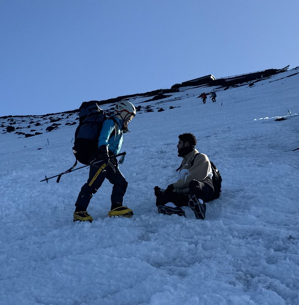 富士山にて、山頂から下降中に座り込んでモゾモゾする人影を見つけました。午後になり気温が下がりクラストし始めた雪面にチェーンスパイクをはいた外国人の登山者。大丈夫？と聞くと怖くて立てない、降りられないと言う。アックスもなく固くなり始めた雪面で滑ったら止まれず助からないかもしれない