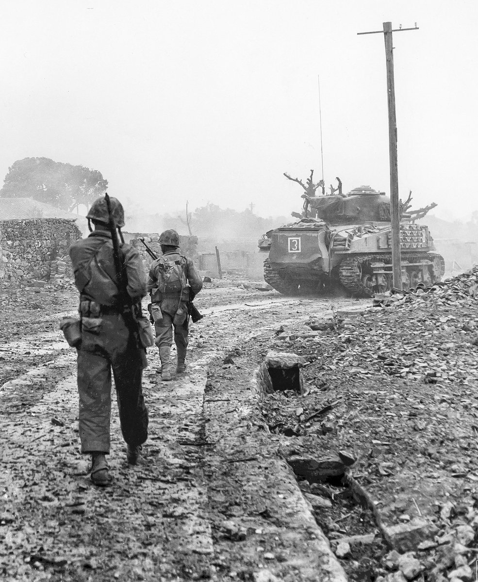 U.S. Marines with the 6th Marine Divison, move behind an M4 Sherman Tank, through the rubbled streets of Naha, during the battle of Okinawa in June 1945. (Photo courtesy of USMC) #USMC #Okinawa #WWII #Military #History