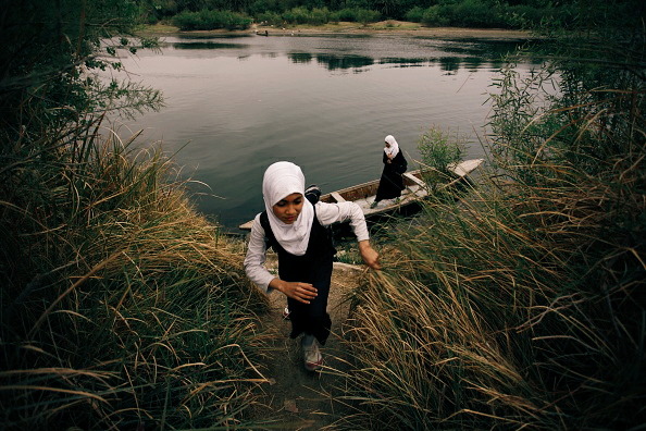 Iraqi school girls paddle a small wooden boat across a river, as they head to school. 2015, Najaf, Iraq. 🇮🇶

📷: Haider Hamdani