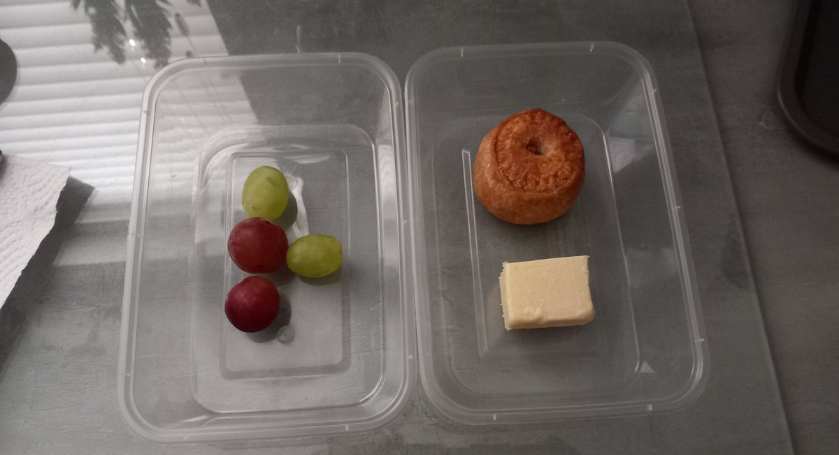 Lunch for tomorrow. A pork pie with a piece of cheese, and grapes.
