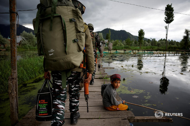 Indian security personnel walk toward their designated polling station past a boy catching fish at Dal Lake, ahead of the fourth phase of India’s general elections, in Srinagar reut.rs/3WKmARr 📷 Sharafat Ali