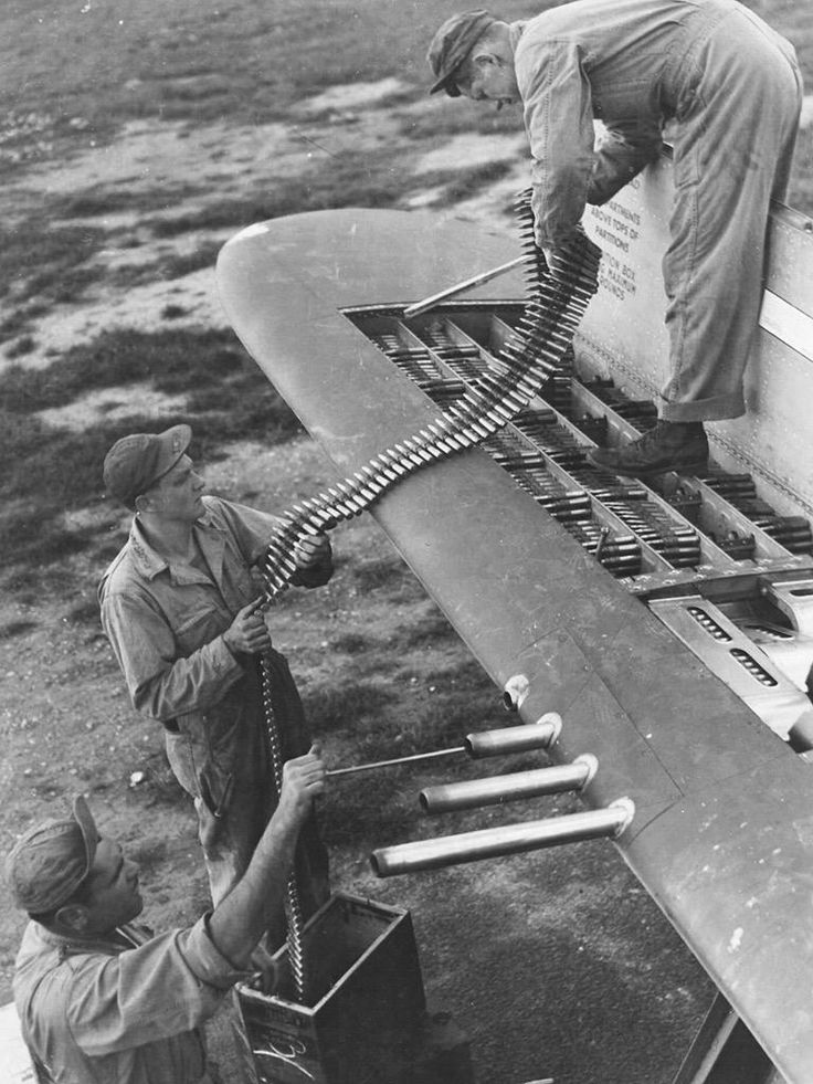 Armorers loading belts of .50 caliber ammunition into the four ammo trays in one wingtip of a P-47 Thunderbolt fighter aircraft. #History #WWII