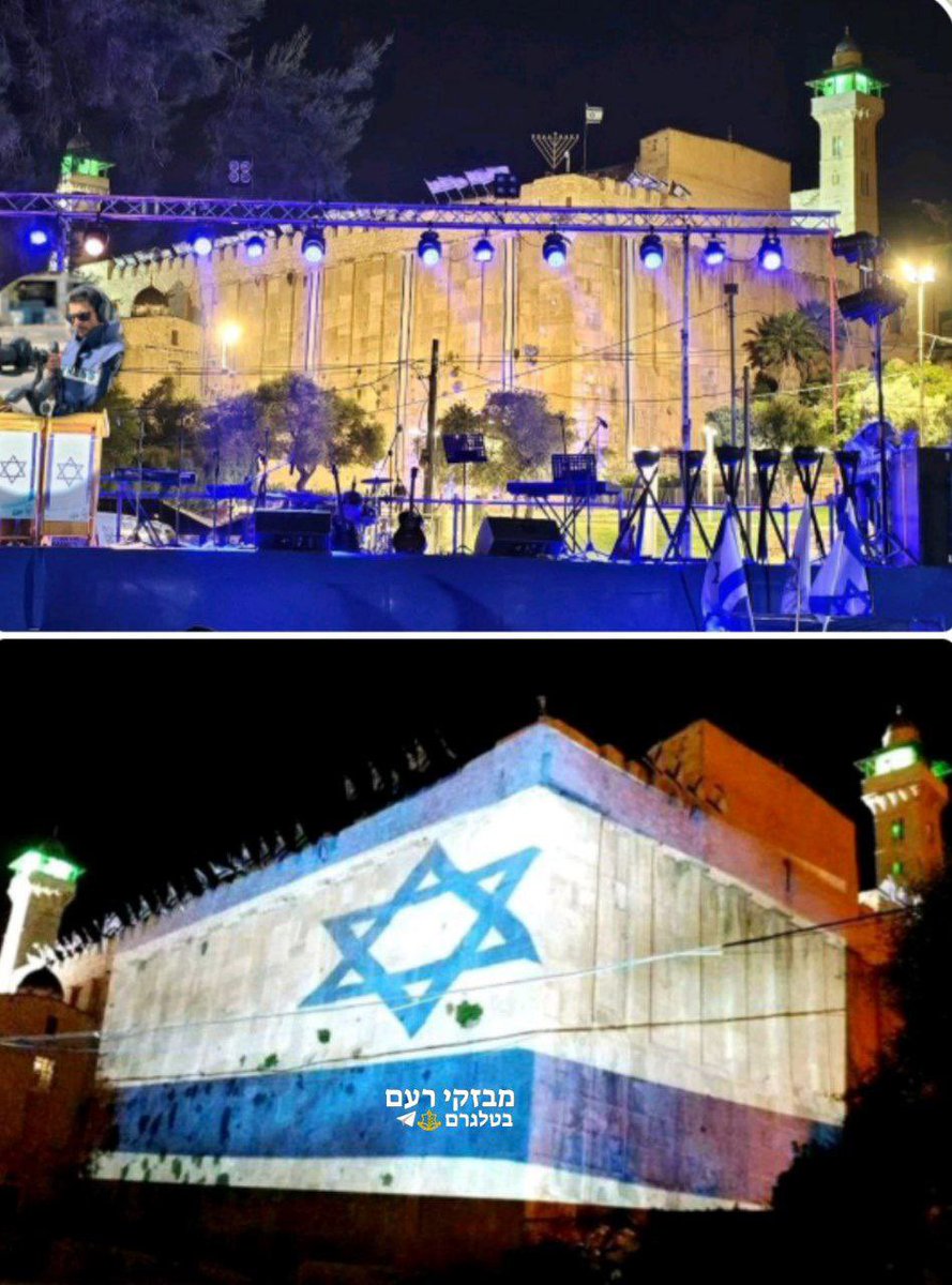 QudsNen's tweet photo. Israeli authorities project an Israeli flag on the walls of the Ibrahimi mosque in occupied Hebron in the West Bank to celebrate the 76th anniversary of the Nakba when zionist militia forcefully displaced over 700,000 native Palestinians from historic Palestine to create "Israel".