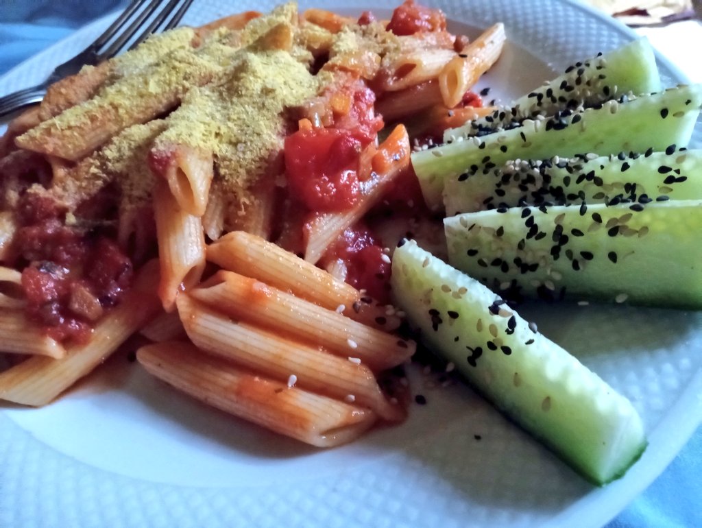 Easy, quick and healthy dinner. #ItsEasyToBeVegan Pasta with sauce and a can of roasted tomatoes added (including garlic & onion & pepper). A LOT of nooch on top along with love 💚 Sliced cucumber on the side. Sesame seeds on everything 😅
