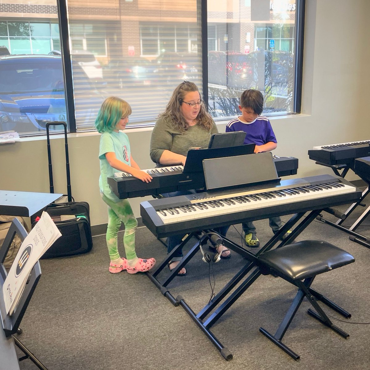 Miss Jen making the most of her small but mighty class. They all gathered around the keyboard and had a blast playing together as one! buff.ly/48CW6EM #musiceducation #musiclessons #musichousekc #musicschool