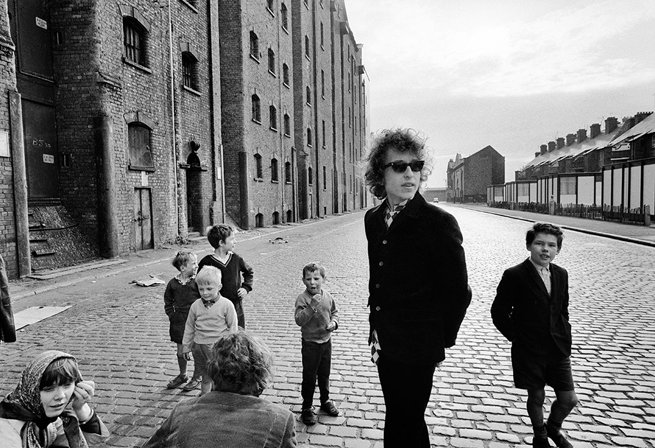14th May - #OTD in 1966 Bob Dylan in Liverpool photographed with a group of children in Dublin St near Stanley Dock. Photo by Barry Feinstein.