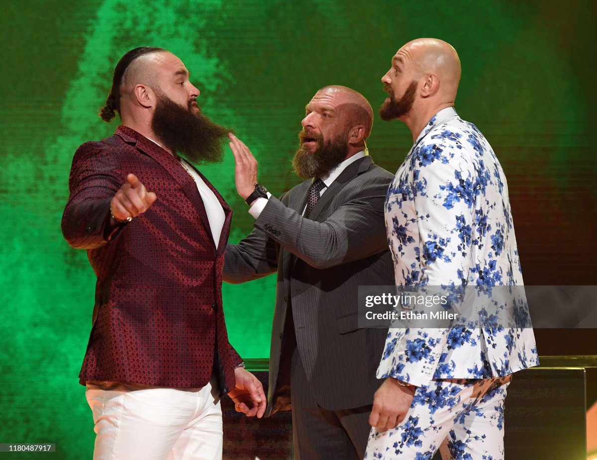 WWE Executive Vice President of Talent, Live Events and Creative Paul 'Triple H' Levesque (C) gets between WWE wrestler Braun Strowman (L) and heavyweight boxer Tyson Fury as they face off during the announcement of their match at a WWE news conference at T-Mobile Arena (2019)