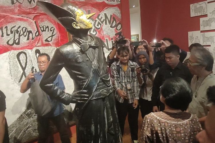 Ganjar dan Megawati Kunjungi Pameran Butet, Patung Pria Kurus Hidung Panjang, Patung pria itu tegap, dengan pose tangan bertolak pinggang. Kepalanya juga mendongak ke atas, dengan hidung panjang seperti pinokio.