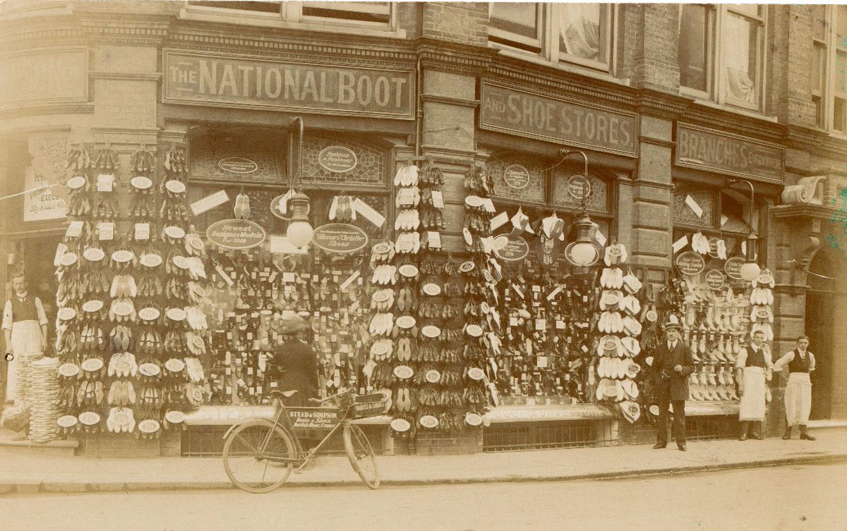 Black and white photograph taken around 1912 showing Norfolk House on the corner of West Street and Hamilton Road, #Cromer, in use as the London Boot and Shoe Company, with a fine display of wares outside.