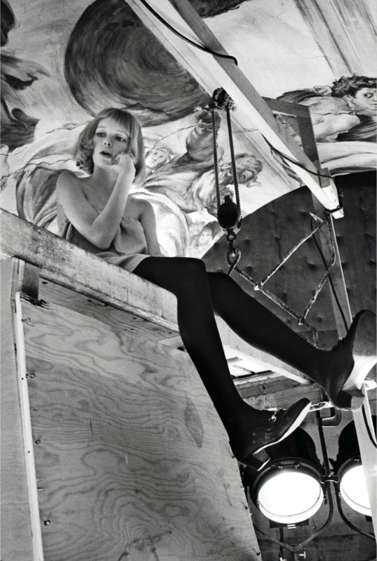 “Mia Farrow perched long legged on the scaffolding of ‘Rosemary’s Baby’ during filming at Paramount Studios”, 1967. Bob Willoughby.