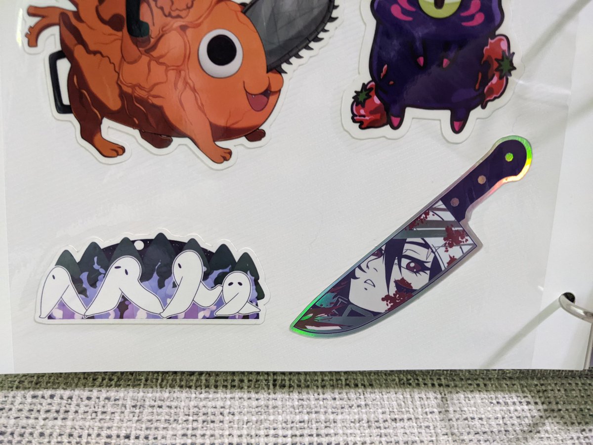 Here are some of the awesome things I got from @yokaniii_ I'm sorry I'm terrible at taking pictures 🫣 I love this Over the Garden Wall standee. Also I use a photo album to keep my stickers safe. Look at these adorable cryptids! And the holo on the Annie knife is so cool! Thanks!