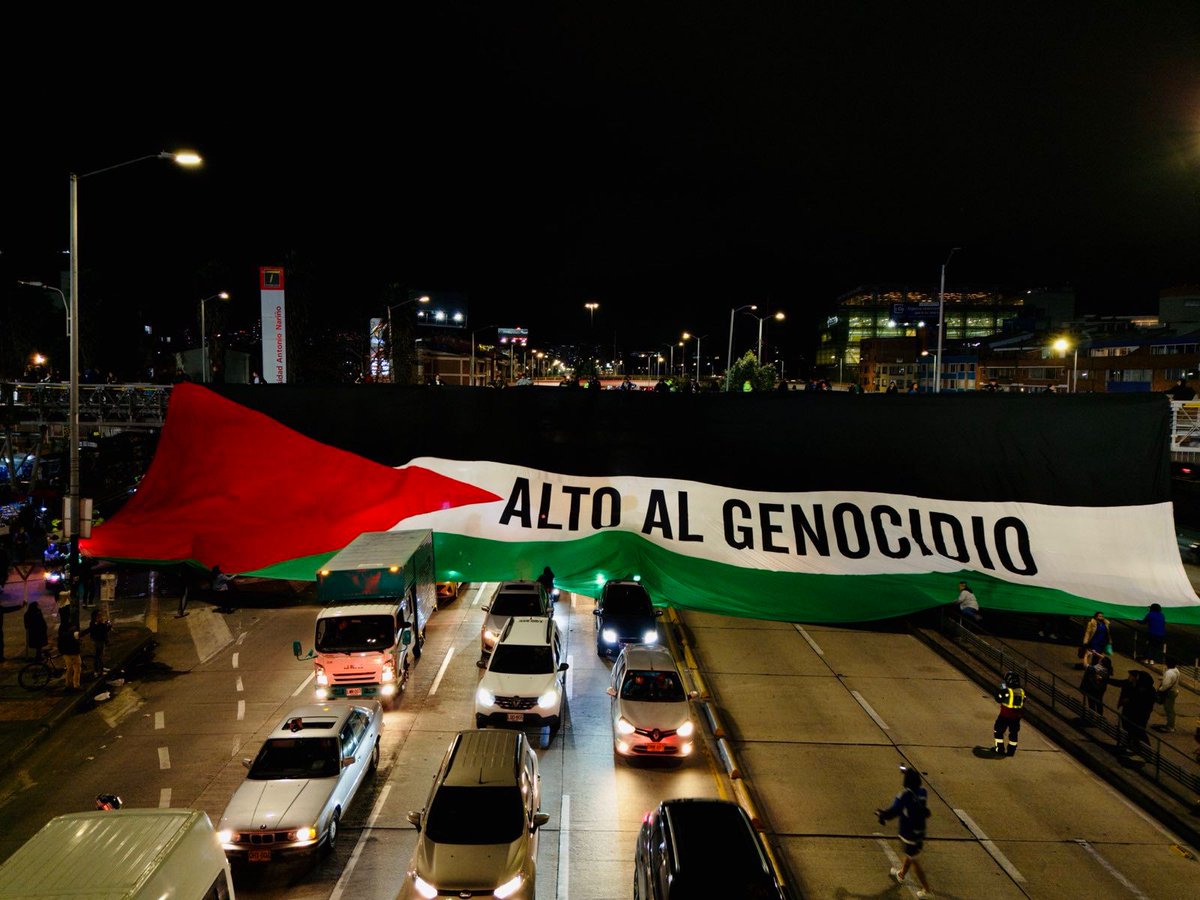 #AEstaHora a las afueras del estadio el campín se despliega bandera en apoyo a #Palestina y pidiendo el alto al genocidio sionista en Gaza.