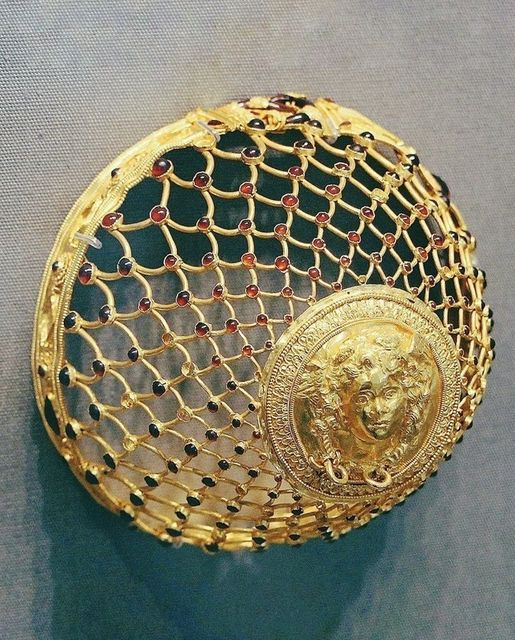 Gold Hairnet, Dating to c. 3rd century BCE, An intricate gold hairnet depicting Medusa that once belonged to a woman from the ancient Greek city of Taras in southern Italy. It is also adorned with dozens of garnets. Altes Museum, Berlin, Credit: @TheClassicalCo