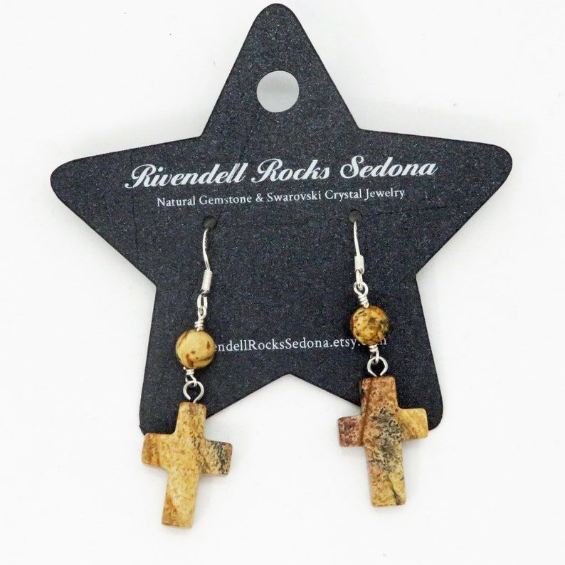 'Picture Jasper Natural Stone Cross Dangle Earrings' by RivendellRocksSedona are the perfect blend of rustic elegance and faith. Handmade with quality and budget-friendly, these earrings are a must-have for any Christian. #HandmadeJewelry #FaithFashion buff.ly/4bCot6E