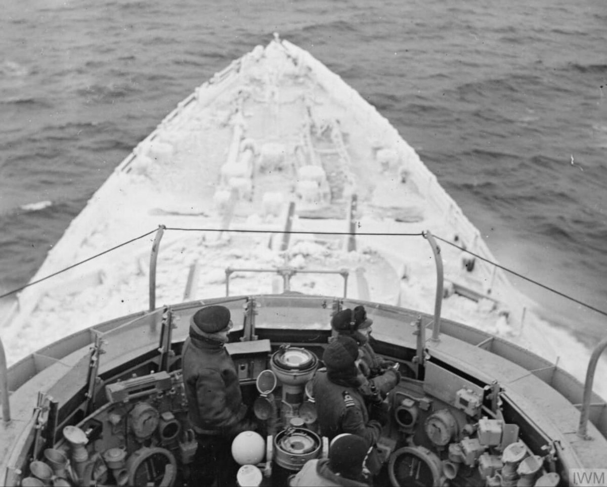 Officers are pictured here on HMS Belfast's original, open bridge which would eventually be replaced by a fully-enclosed bridge during a later refit.

As the background of the photograph suggests, those working on the open bridge would have to face the icy conditions of the