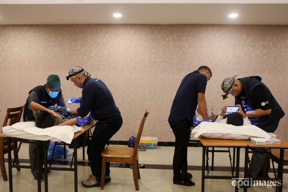 Doctors perform circumcisions on two boys during a mass circumcision ceremony for children in Banda Aceh, Indonesia, 15 May 2024. 📸 EPA / Hotli Simanjuntak