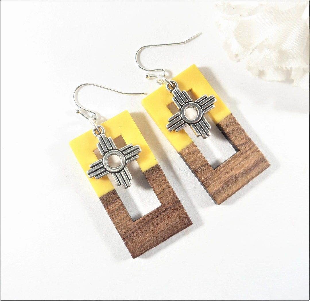 These unique yellow Zia charm earrings are made from rectangular resin and wood charms with antique silver Zia charms dangling 2 inches from top of silver plate ear wires. buff.ly/3WLb1t1  #SantaFe #NewMexico #etsyshop #Albuquerque #etsyjewelry #shopsmall #wiseshopper