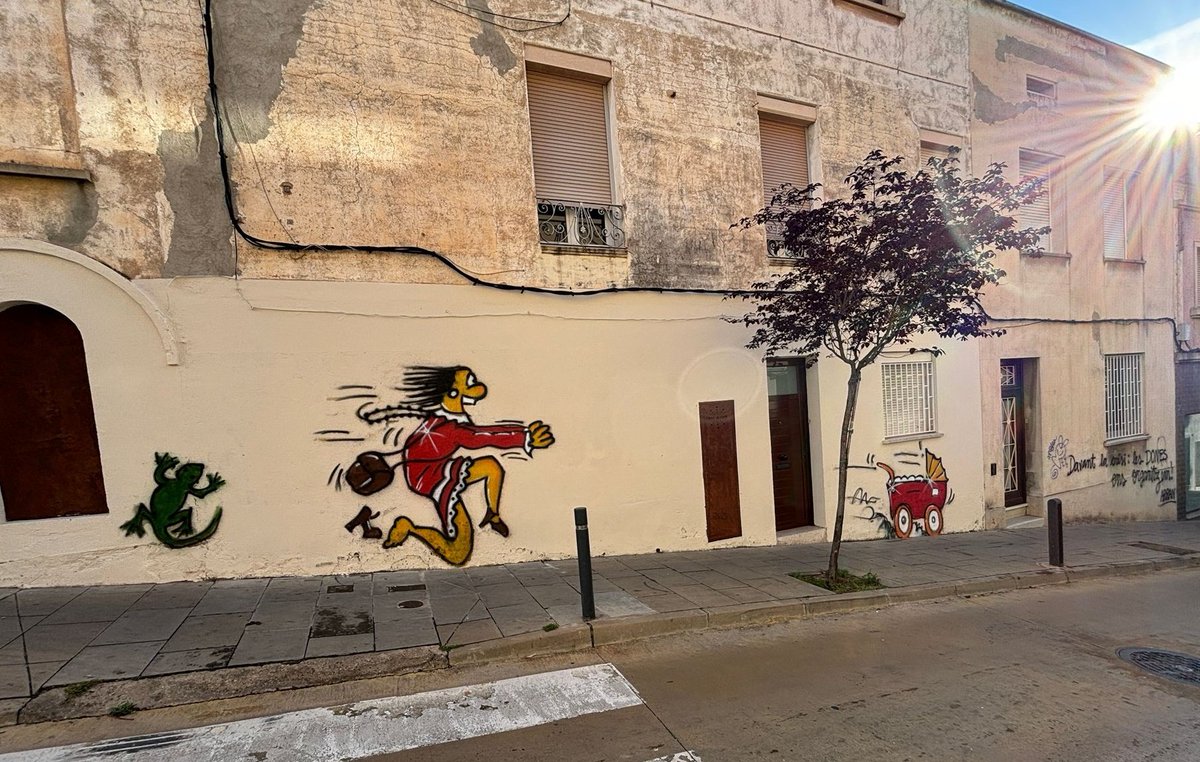 🎨🔴 #ArtUrbà - Els artistes que als anys 80 van fer el grafit del c/Badó (senyora que se l'hi escapava el cotxet), l'han repintat. 👉A més, 36 anys després n'han fet un de nou al c/Bonavista: el nadó que baixava pel c/Badó és ara qui perd la mare que va en cadira de rodes.
