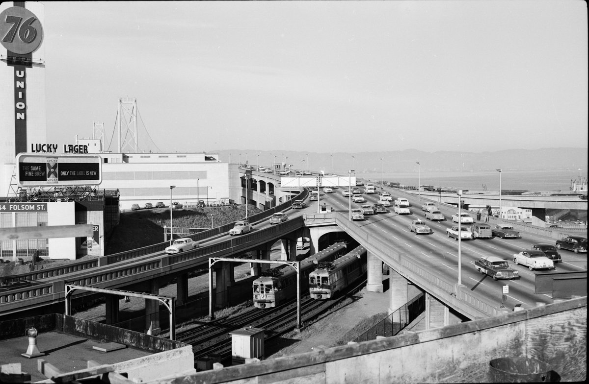 1956, a dynamic view of the Bay Bridge from about 2nd & Harrison. Haven't done much research but things that stand out are the Key System trains from the lower deck, undivided two-way traffic on the top (!) , and a couple of workers standing on the sidewalk #sfhistory