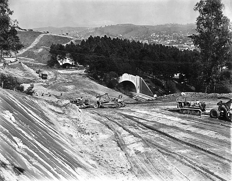 [1941] Rushing the work to relieve the bottleneck of the Figueroa tunnels for traffic on the Arroyo Seco freeway that runs between Los Angeles and Pasadena, crews are shown building the new parallel road through Elysian Park. (Herald Examiner Collection) buff.ly/3L3WS4s