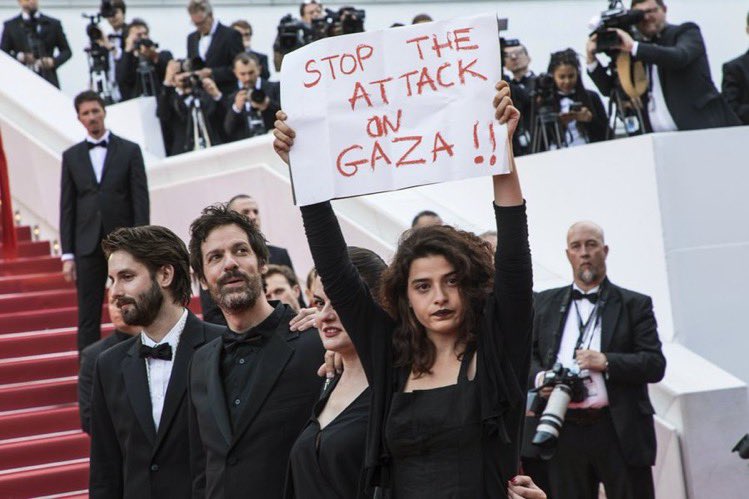 Lebanese actress Manal Issa holds a sign that reads 'Stop the Attack on Gaza' at the premiere of 'Solo: A Star Wars Story' at the Cannes film festival in 2018 
(Before October 7th)