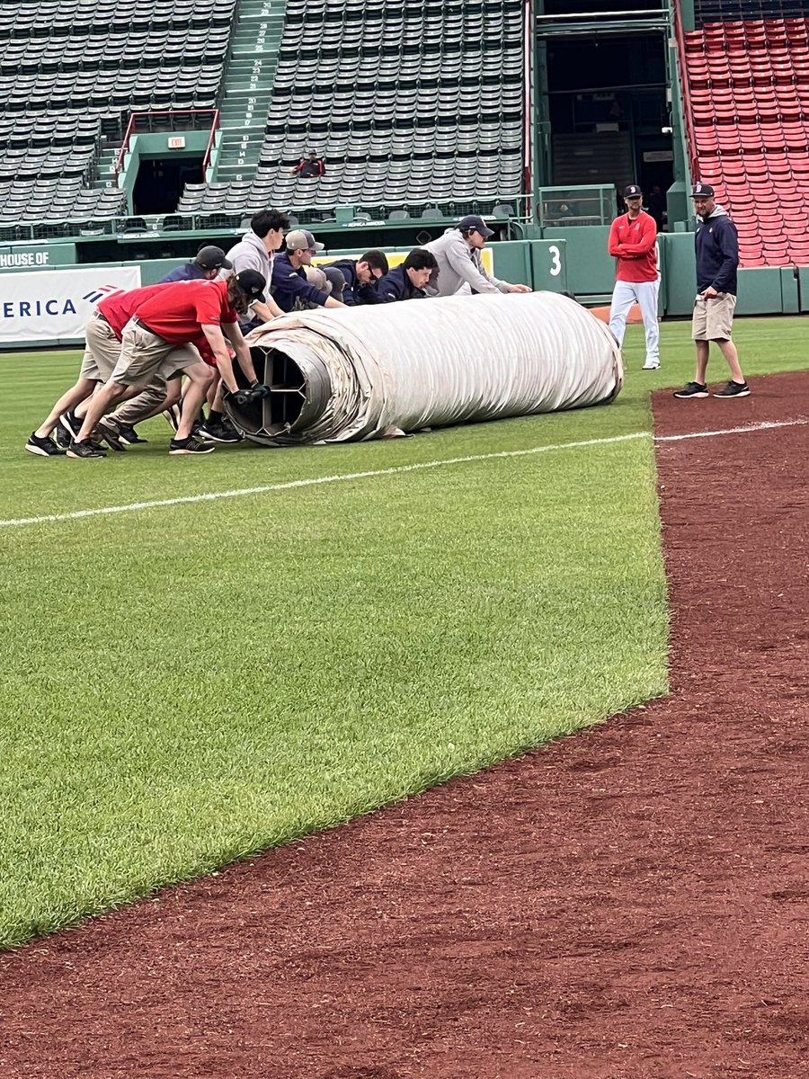 Tarp coming off after a cloudy afternoon at Fenway.