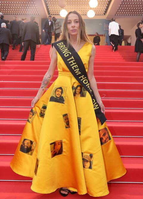 Festival de Cannes : Laura Blajman-Kadar, rescapée des massacres du 7 octobre, arbore une robe jaune ornée des visages des otages retenus par le Hamas à Gaza. La robe a été confectionnée par la créatrice Lisa Korn. 📸: Collectif du 7 octobre (@7octobre_off) pour la Côte d'Azur