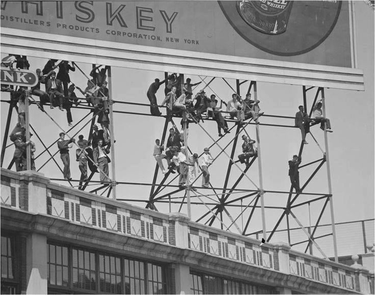 Red Sox fans who couldn't get a ticket to the game resorting to Plan B - finding a spot with a view on the bottom of a rooftop billboard 1937. @BPLBoston