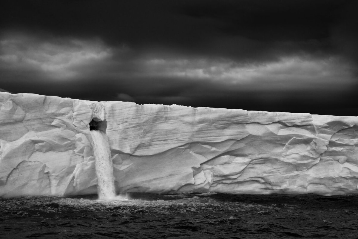 'There is an ironic beauty in the collapse of our global climate, and the sound of meltwater rushing from this void in the ice amidst the Arctic's deafening silence' Via Paul Nicklen Photography