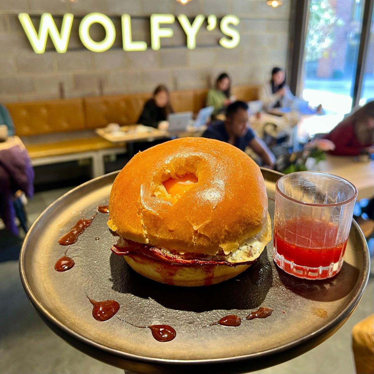 Start your day with a bang at Wolfy's Bar! Our Bacon Bagel 🥯 is the ultimate breakfast treat, topped with creamy avocado and spicy chili jam egg 🍳 Try it now, it's our bestseller! #breakfastgoals #baconbagel #eggsandwich #delicious linktr.ee/wolfysbar