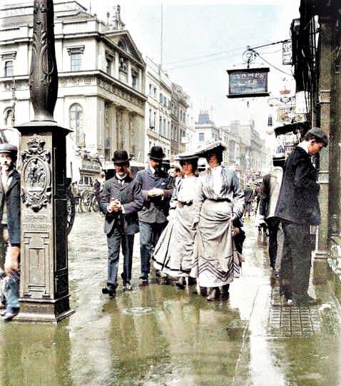 On the Strand near Charing Cross in London, the ladies hold up their skirts to stop their dresses getting wet in the puddles, while the gentlemen walk on the roadside to protect them from splashes, c1900. (c) Museum of London, Heritage Images, science Photo Library