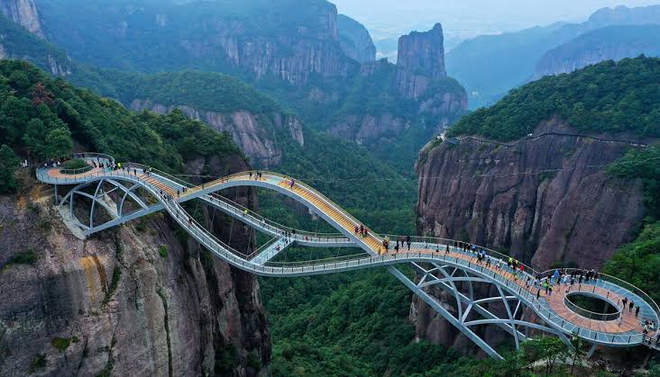 25. Ruyi Bridge, Taizhou, China

This footbridge, made up of three bridges, opened in September 2020 and features a glass-bottomed walkway. It stands 140 meters high above the Shenxianju Valley and spans 100 meters, offering visitors a unique and thrilling perspective of the