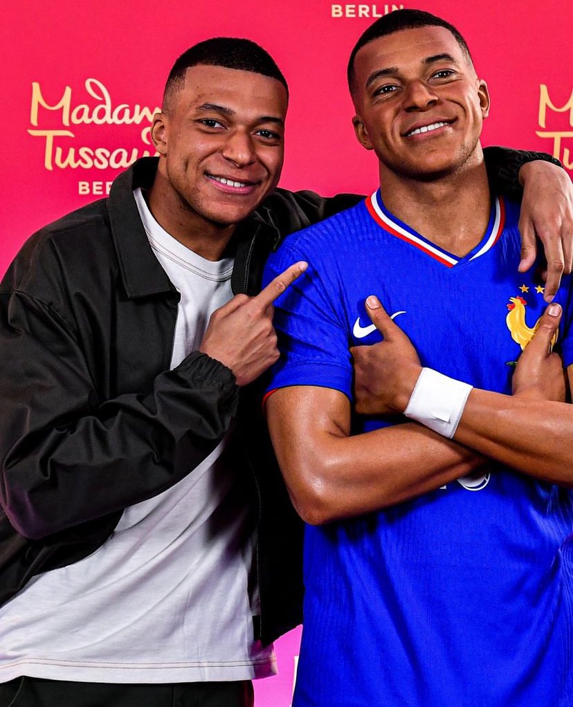 There are two Mbappés in this picture. One is the wax model and the other is the actual player.

Which is which? 🤔