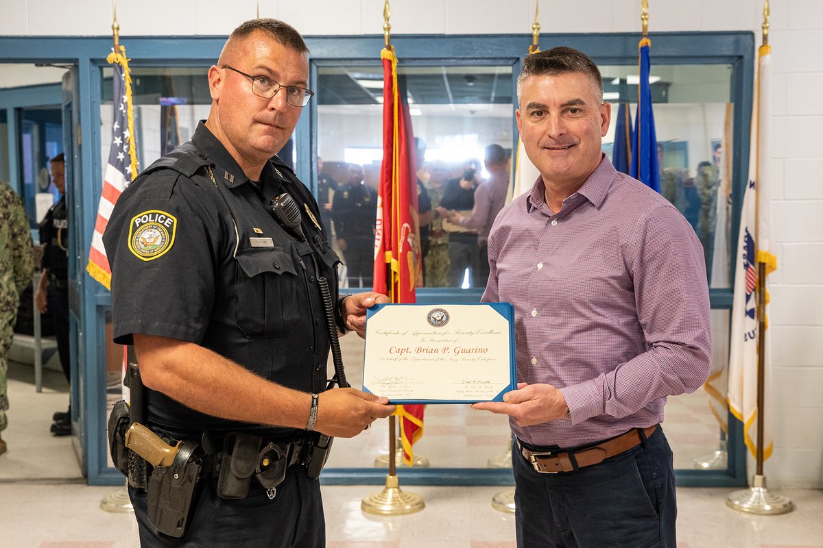 Deputy Under Secretary of the Navy (Intelligence and Security) Victor Minella presents Naval Air Station (NAS) Pensacola Navy Security Forces Capt. Brian Guarino a Certificate of Appreciation for Security Excellence May 14 during a familiarization tour of the installation.