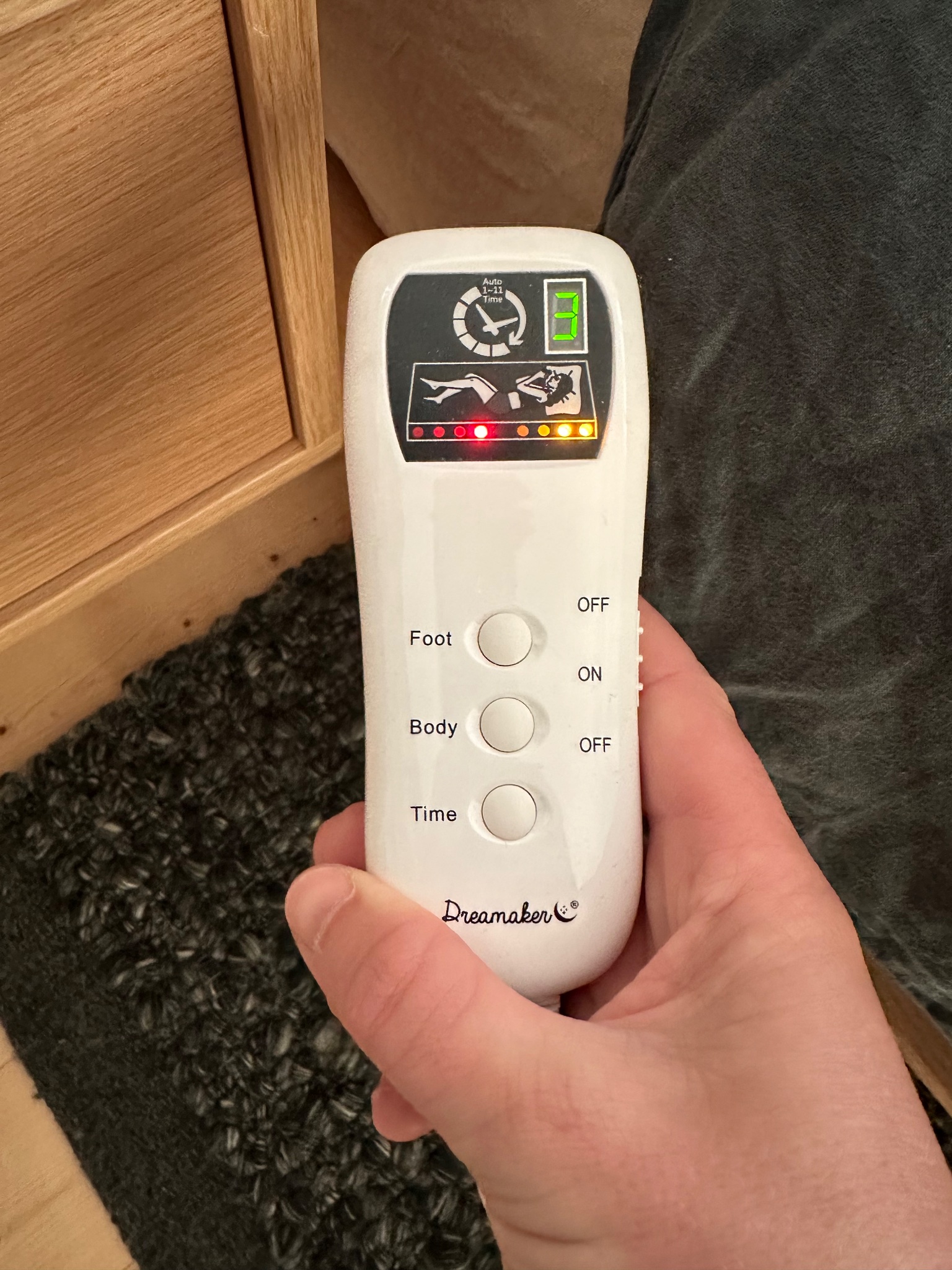 Photo of my dreammaker controller, showing a person lying down and a timer, with 3 buttons, and a side switch.