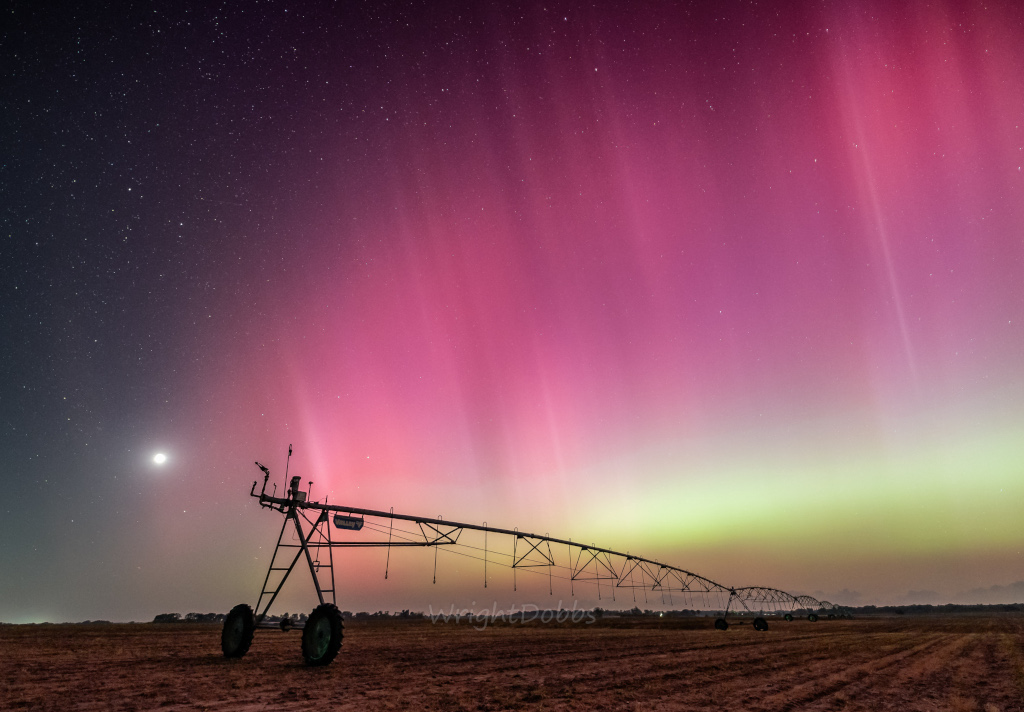 A familiar sight from Georgia, USA, the Moon sets near the western horizon in this rural night skyscape. Captured on May 10 before local midnight, the image overexposes the Moon's bright waxing crescent at left in the frame. A long irrigation rig stretches across farmland about