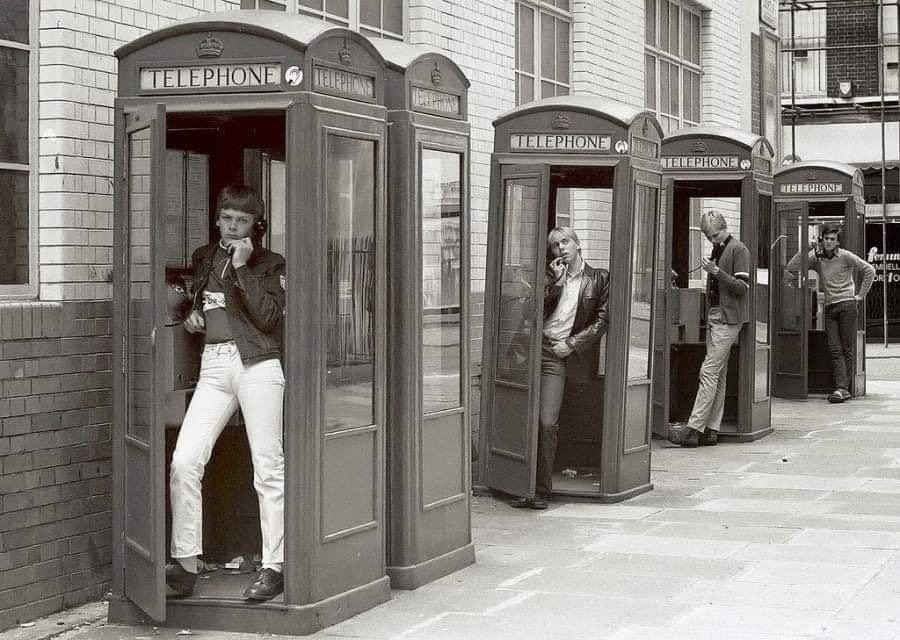 A photograph of London teens in phone boxes taken circa 1980s