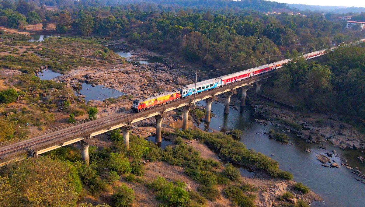 A picturesque tapestry of nature unfolds as a train journeys between Sindhudurg Railway Station and Kankavli Railway Station in Maharashtra. 🚆