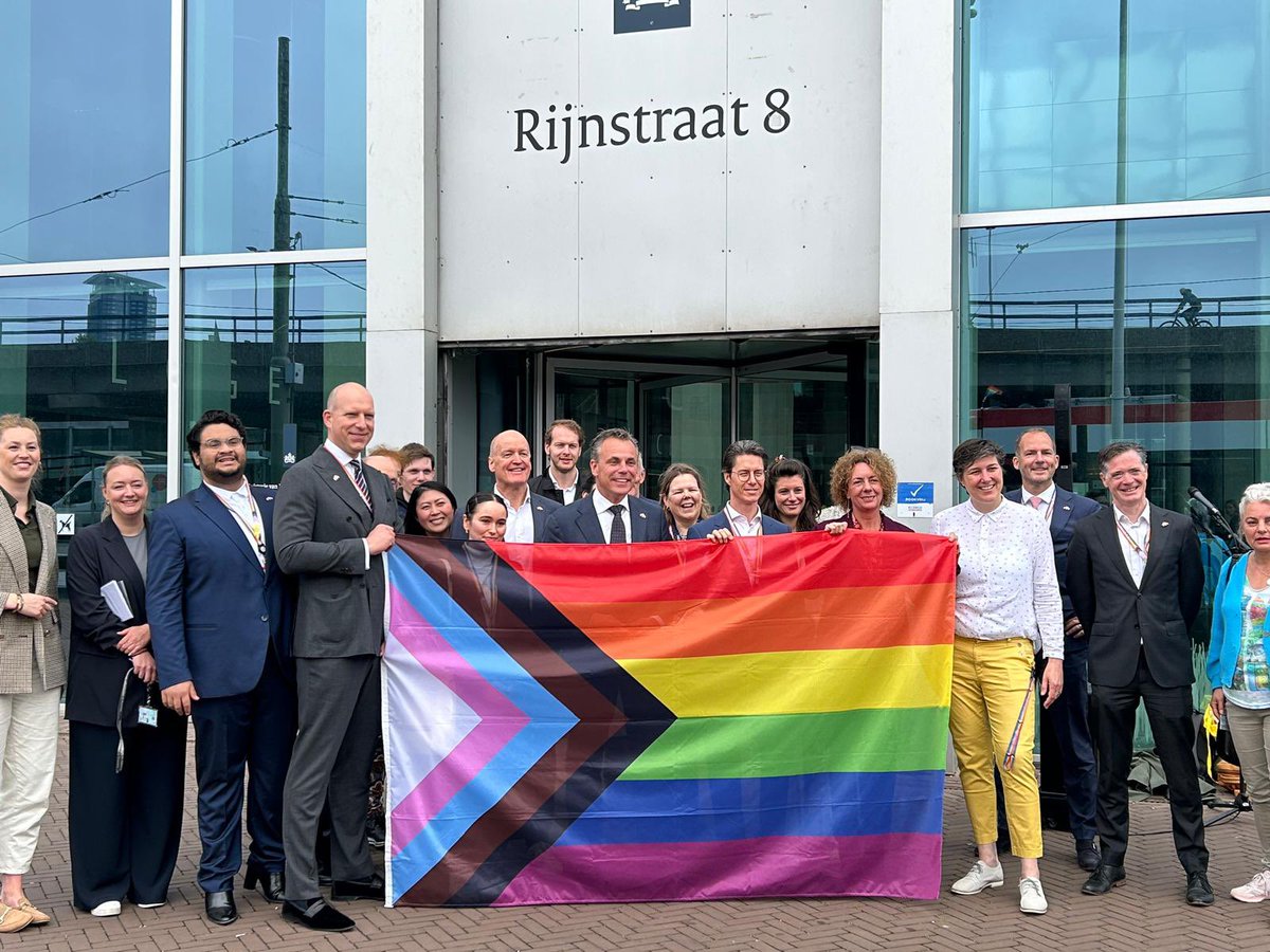 Vanmorgen werd vanwege #IDAHOBIT de progressvlag gehesen bij ons kantoor in Den Haag. Minister @markharbers was daarbij: “Bij de rijksoverheid kun je jezelf zijn, daar staat deze vlag symbool voor.”