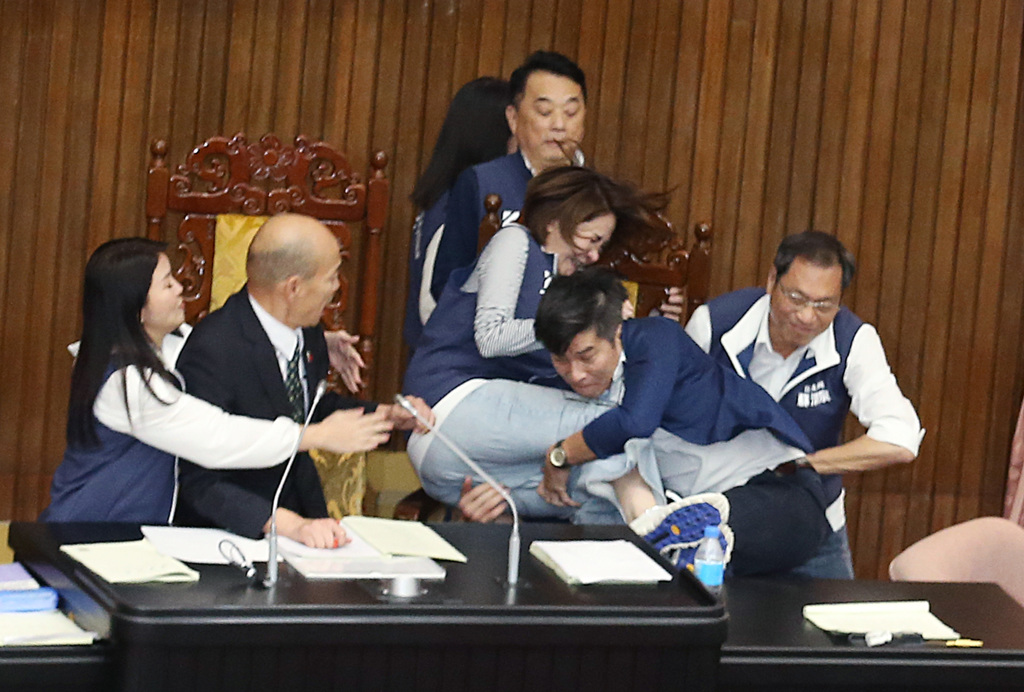 '民進黨立委鍾佳濱（右二）翻上桌衝向主席台，擋在院長韓國瑜（左二）前的國民黨立委陳菁徽（中右）前被鍾一把抱住...'

#Taiwan's parliament the Legislative Yuan today. The woman is a @kuomintang legislator and the male grabbing her is a @DPPonline legislator.

chinatimes.com/realtimenews/2…
