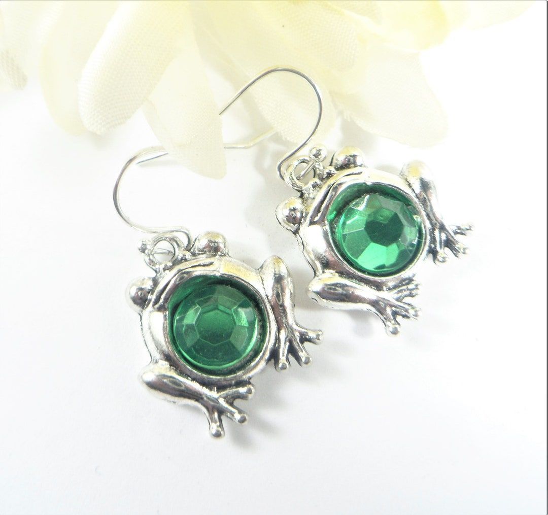 Adorable frog earrings made from antique silver frog charms with faceted green crystal in tummy all dangling 1 1/4 inches from top of silver plate ear wires. Great for any frog lover! buff.ly/44G2Hww #NewMexico #etsyshop #froglover #etsyjewelry #shopsmall #wiseshopper