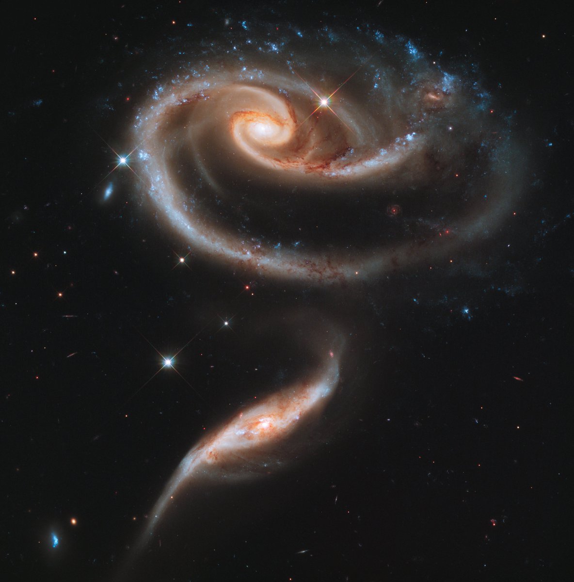 The image below shows two galaxies colliding. This pair of colliding galaxies is called Arp 273, which is located 300 million light-years away. The outer arm of the larger galaxy is distorted. The reason is that the smaller galaxy had an unsuccessful hit with the larger galaxy!