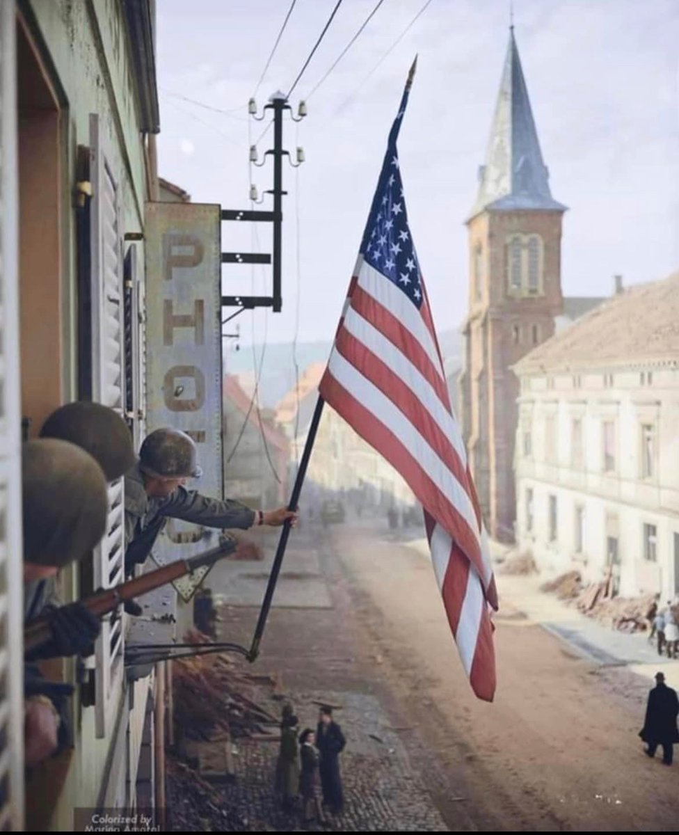 Captain Thomas Garahan, a company commander in the 100th Infantry Division, raises the flag of the United States that was made in secrecy by a local French girl in Bitche, France while the region was under the control of Nazi Germany. 🇺🇸 @marinamaral2 on the colorization 🎨