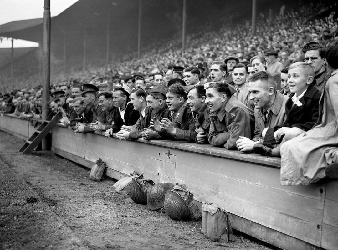 A Photograph of British and Commonwealth servicemen watching a friendly wartime football game between England and Scotland. Taken at Wembley Stadium, London, England. On the 4th of October in 1941.
