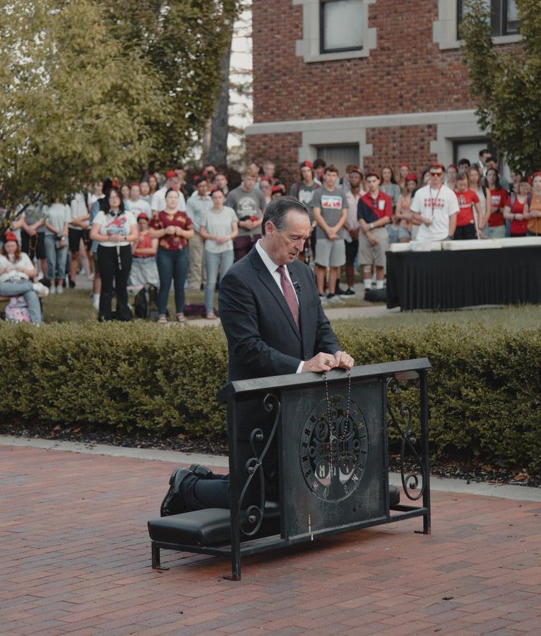 Repost- Here is where Harrison Butker delivered his commencement speech. Benedictine College President Stephen Minnis is on his knees, leading the students in praying the Rosary for themselves, the college, the nation, and the entire world.