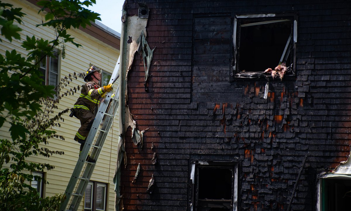 A firefighter scales a ladder on the side of a house on Hunter Street in Halifax that was heavily damaged in a fire earlier today. 📸: @ryantaplinhfx